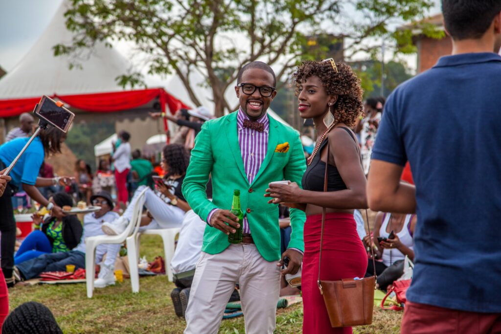 A man standing in a green jacket, smiling at the camera